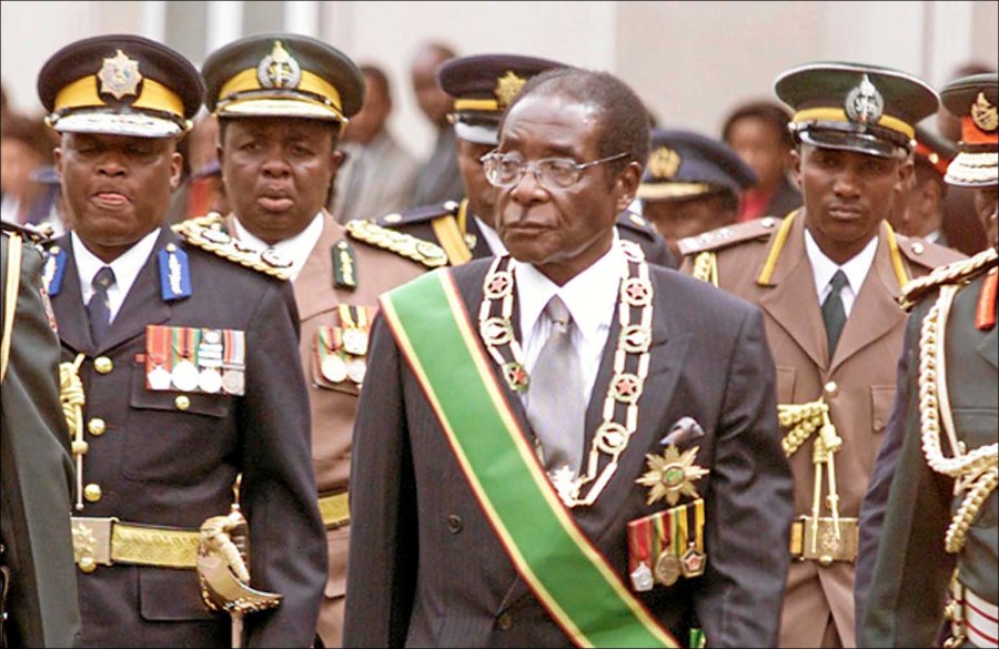 President Robert Mugabe, center, inspects a guard of honor at the opening of Parliament in Harare, Zimbabwe Tuesday, July 22, 2003. Opposition lawmakers decided not to walk out of the ceremony breaking their boycott of official events addressed by Mugabe. (AP Photo)