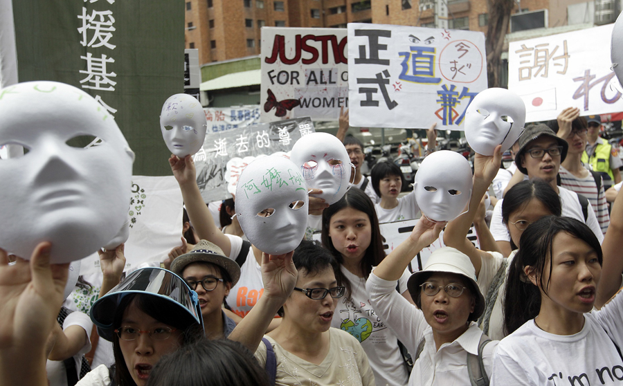 Activists holding masks take part in a protest in front of the Japan Interchange Association, the de facto Japanese embassy, in Taipei, August 14, 2013. Protesters and supporters of "comfort women" who were forced to become sex slaves during World War II urged the Japanese government to formally acknowledge, apologize and accept its responsibility over comfort women for Japanese troops during World War II, according to local media. The Chinese characters on the placard (C) reads, "Apologize formally." REUTERS/Pichi Chuang (TAIWAN - Tags: POLITICS CIVIL UNREST CONFLICT)